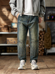 Men's blue straight leg jeans with patterned knee panels and distressed wash.
