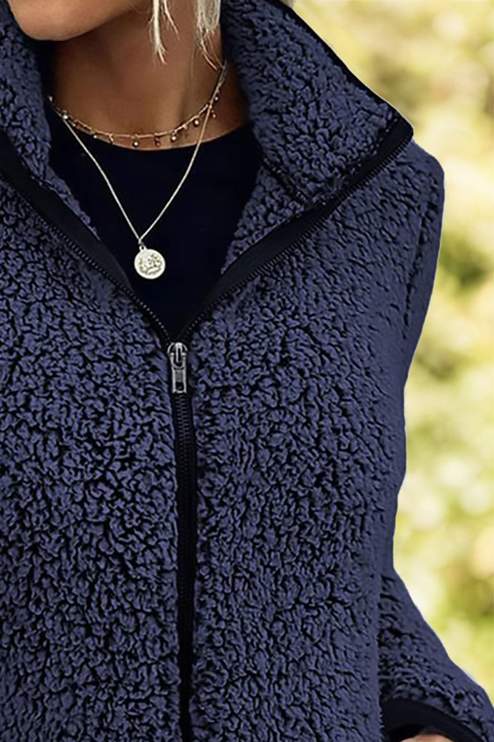 Navy teddy fleece zip-up jacket with a stand collar and zipper detail.
