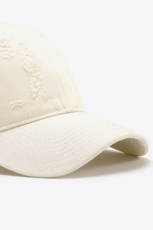 Cream distressed baseball cap with curved brim and stitched details