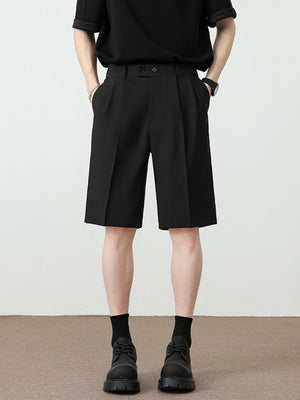Black chino shorts with loose fit and pleated detail, mid-thigh length.