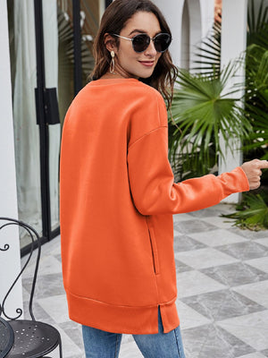 Pumpkin orange crewneck sweatshirt with extended hemline and side pocket detail.