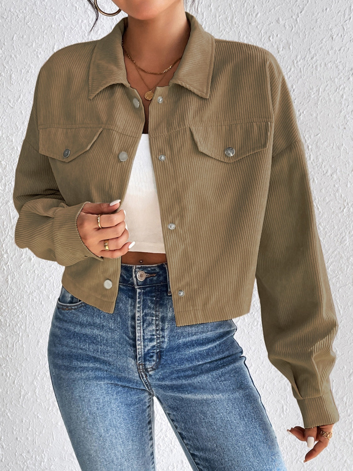 Cropped taupe corduroy snap-front jacket with chest pockets and a collared neckline.