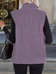 Purple fleece zip-up vest with ribbed texture and mock neck, worn over a black long-sleeve shirt.