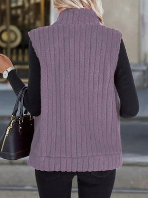 Purple fleece zip-up vest with ribbed texture and mock neck, worn over a black long-sleeve shirt.