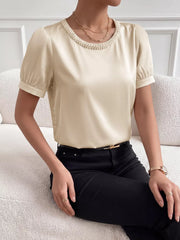 Pearl-trimmed satin bodysuit with short puff sleeves and a round neckline.