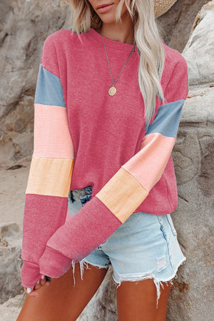 Colorblock sweatshirt with pink, blue, and peach sleeves and a crew neckline.