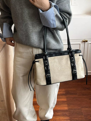 Two-tone suede tote bag with black leather trim and buckle details.