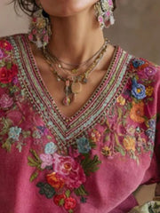 Embroidered deep rose V-neck blouse with floral details and layered necklaces.