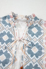 Geometric print blouse with ruffle neck and tassel tie detail in floral colors.