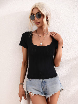 Black knit top with scalloped square neckline and short sleeves, featuring a subtle open-knit pattern.