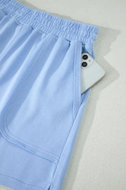 Light blue pocketed shorts with elastic waistband and phone detail.