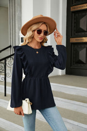 Navy textured ruffle peplum blouse with long sleeves and cinched waist.
