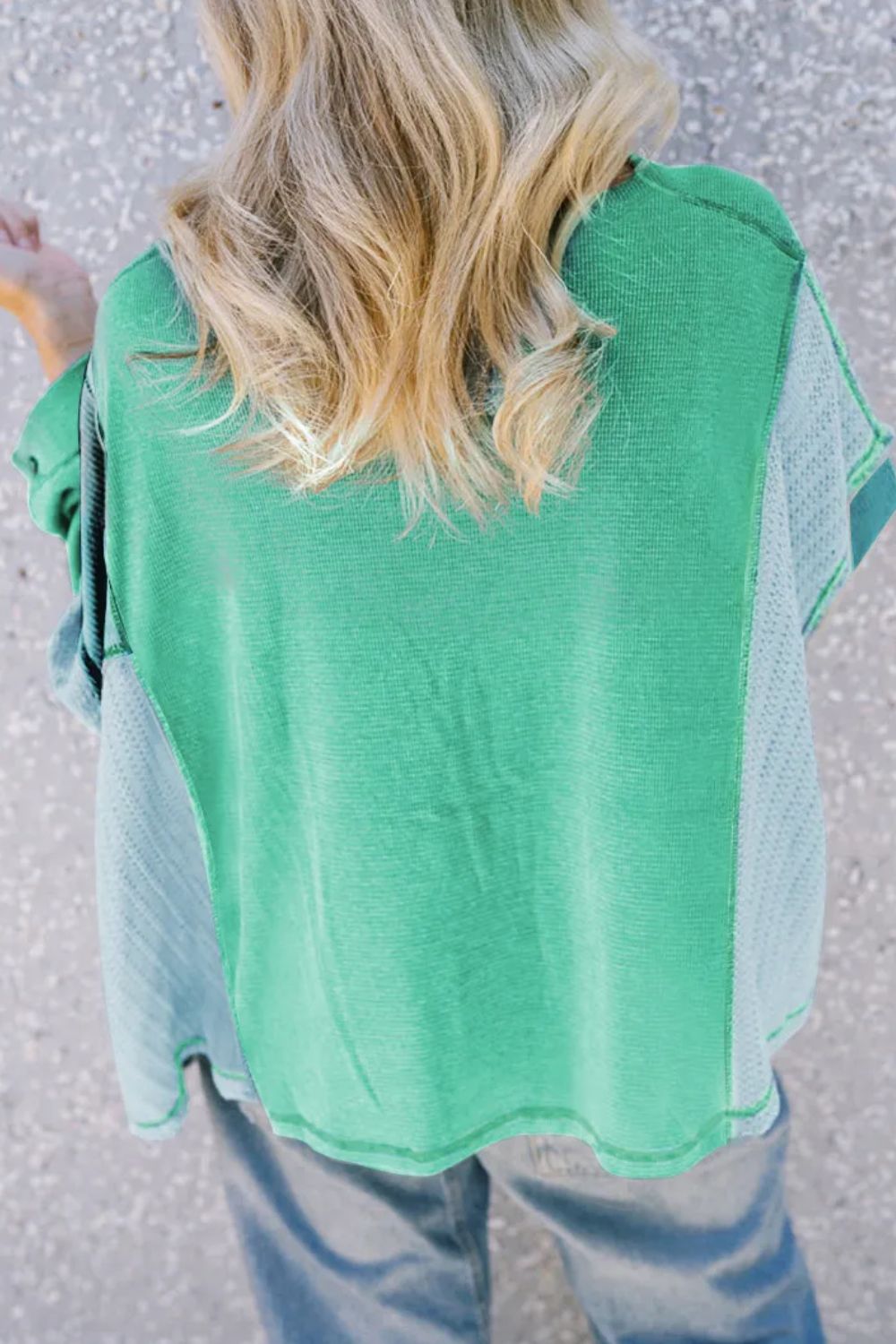 Green waffle knit blouson top with contrasting light blue panels and a relaxed fit.