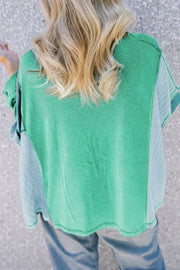 Green waffle knit blouson top with contrasting light blue panels and a relaxed fit.
