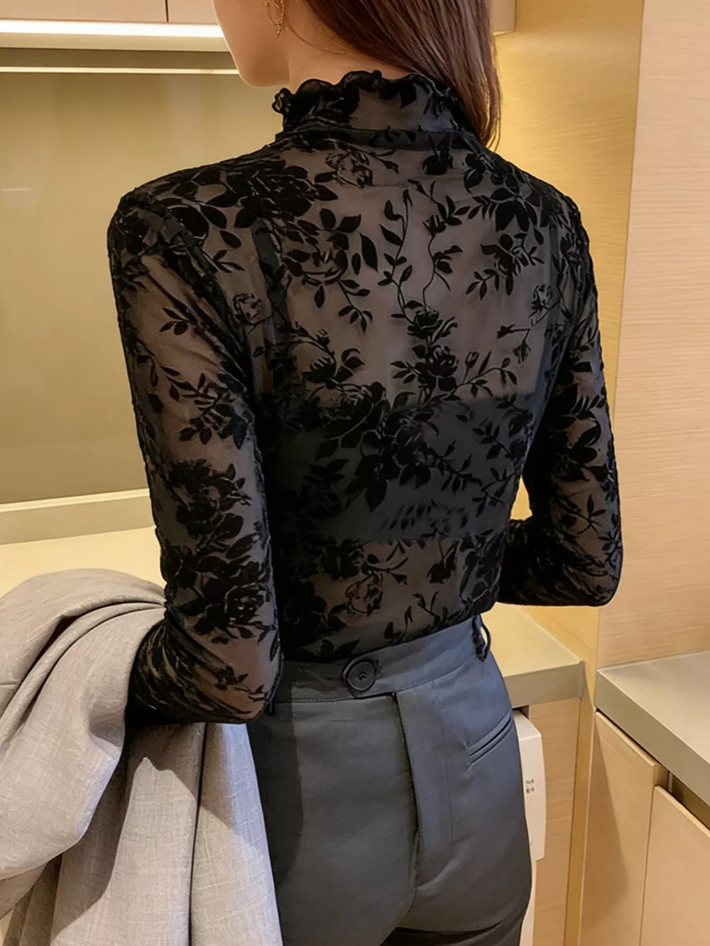 Black sheer floral fitted t-shirt with ruffles and long sleeves.