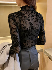 Black sheer floral fitted t-shirt with ruffles and long sleeves.