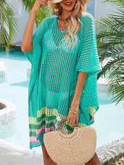 Turquoise crochet beach cover-up with rainbow stripe hem, V-neck, and short sleeves.