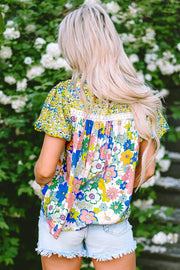Floral patchwork blouse with puff sleeves and lace trim, featuring a colorful floral print.