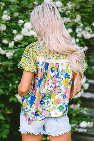 Floral patchwork blouse with puff sleeves and lace trim, featuring a colorful floral print.