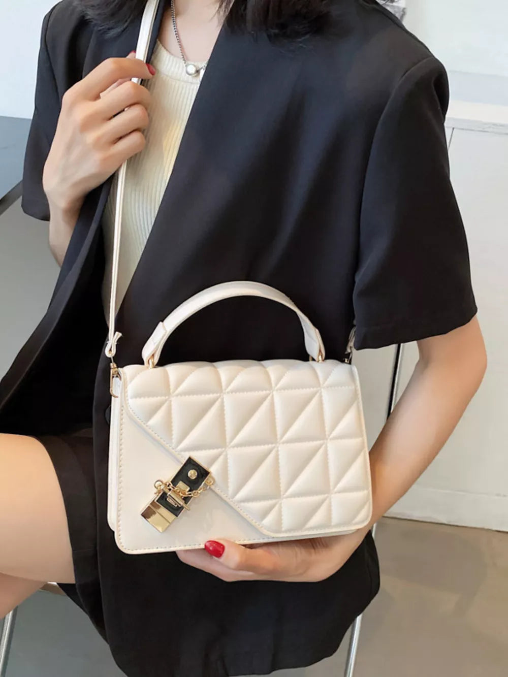 Diamond quilted PU leather crossbody bag in beige white with gold hardware lock detail.