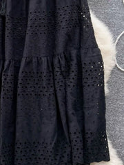 Black eyelet tiered maxi skirt with cutout details and ruffled tiers.