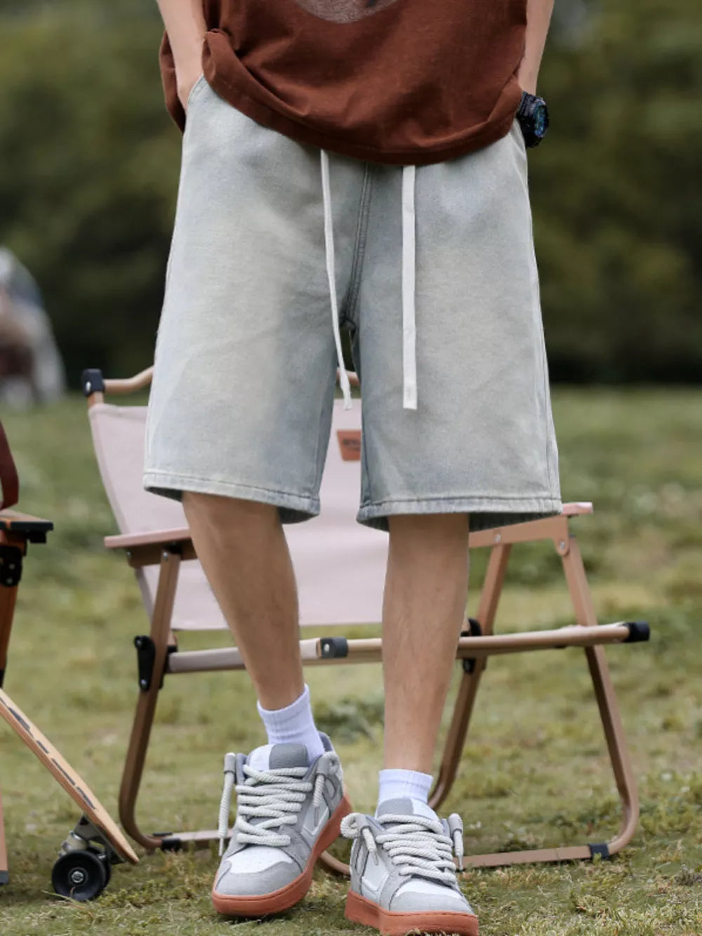 Light blue relaxed fit denim shorts with white drawstring and pockets.