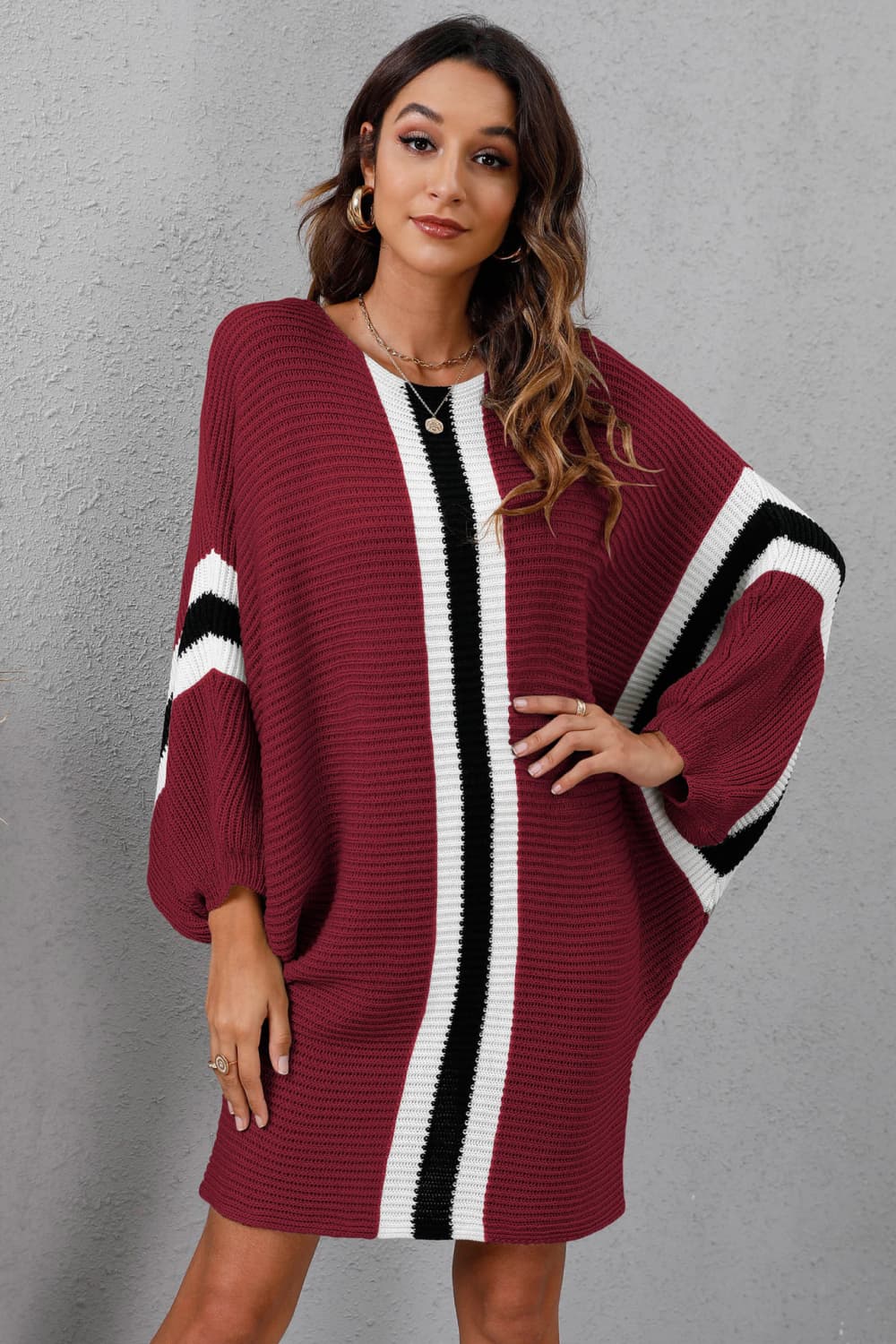 Burgundy oversized knit dress with vertical black and white stripes and striped sleeves.