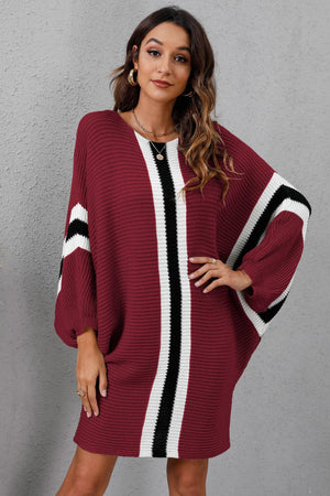 Burgundy oversized knit dress with vertical black and white stripes and striped sleeves.