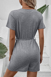 Gray Dawn button-front romper with short sleeves and a tie waist detail.