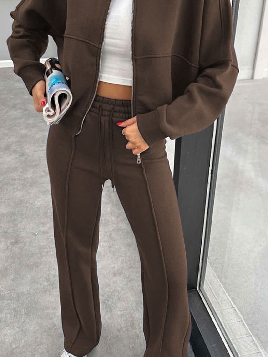 Crimson bomber jacket and wide-leg tracksuit in coffee brown with drawstring waist and zippered pockets.