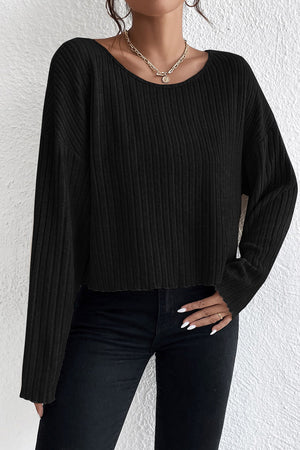 Black ribbed knit off-shoulder top with long sleeves and a cropped hem.