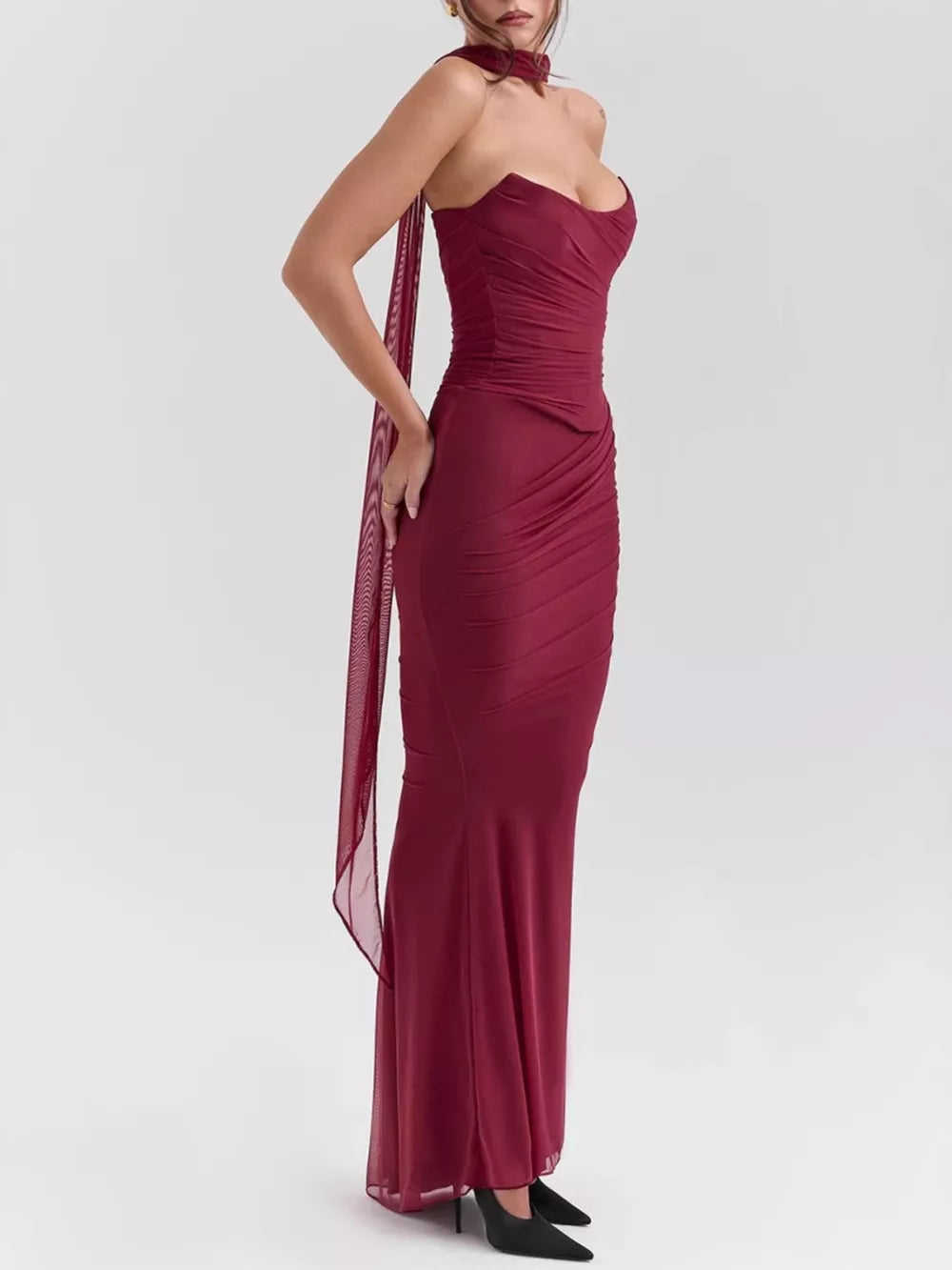 Burgundy sweetheart ruched maxi dress with sheer scarf detail.
