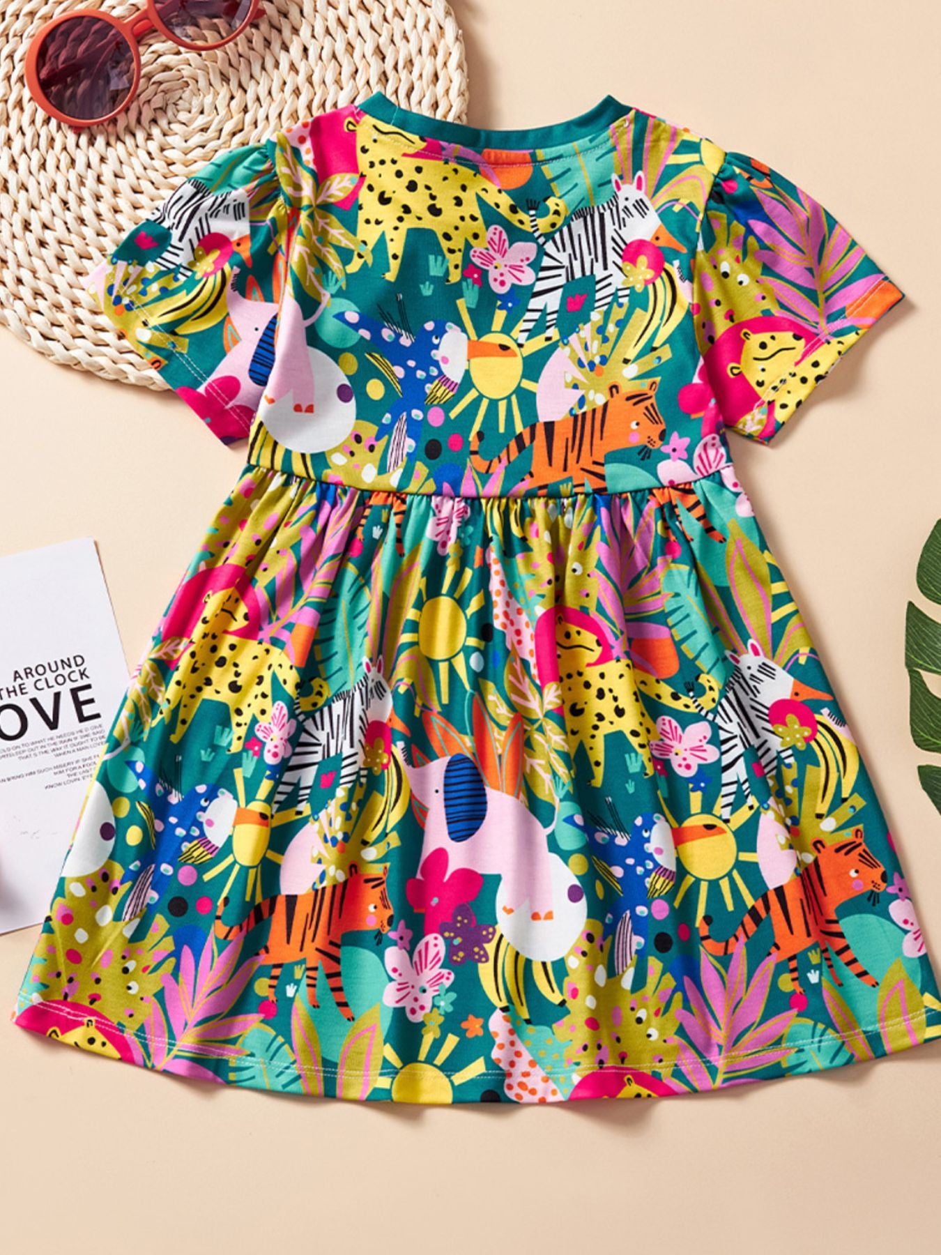 Toddler a-line dress with short sleeves and a playful jungle animal print in vibrant colors.