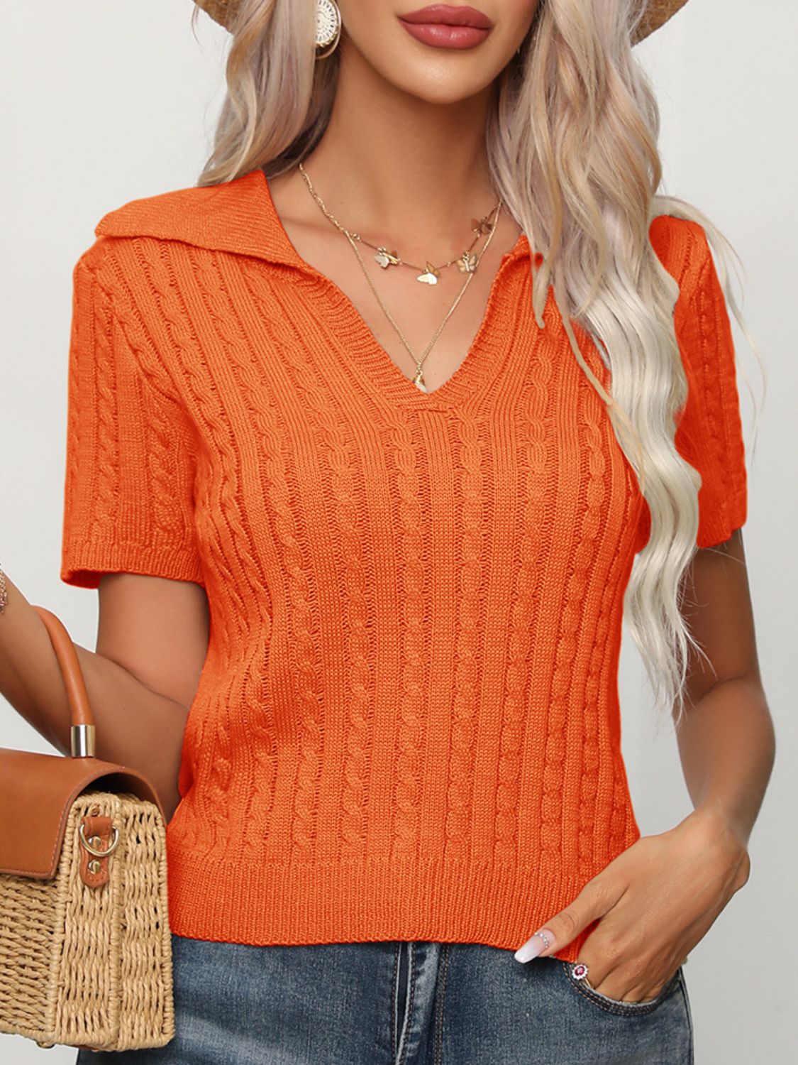 Orange cable-knit short sleeve polo sweater with a V-neck.