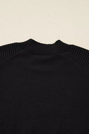 Black acrylic knit sweater with mock neck and ribbed balloon sleeves.