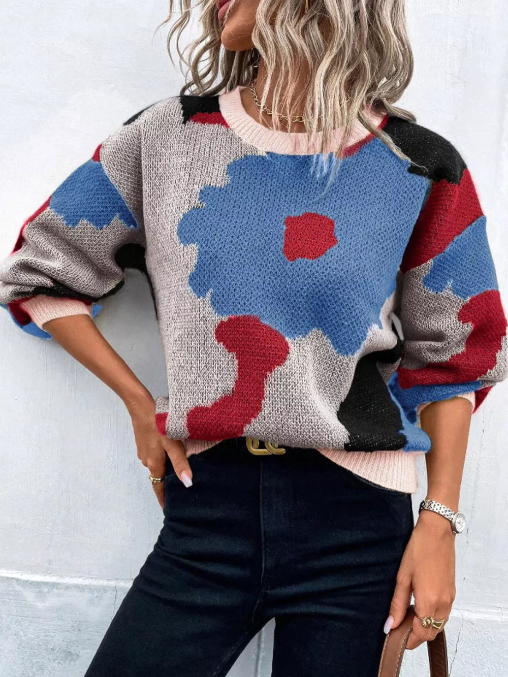 Abstract floral knit sweater with round neck in blue, red, black, and gray.
