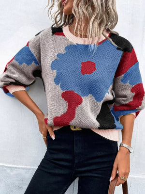Abstract floral knit sweater with round neck in blue, red, black, and gray.