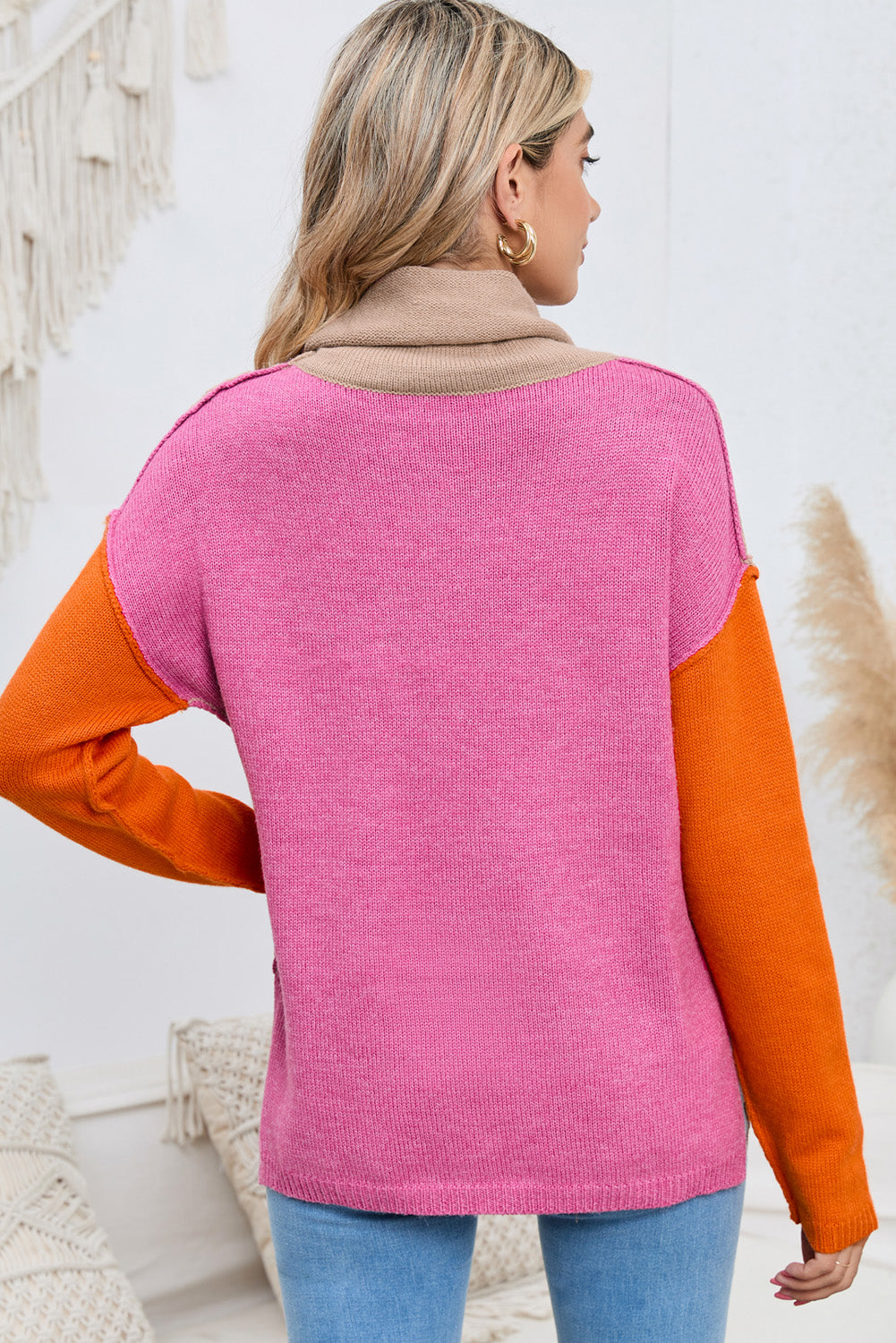 Colorblock knit turtleneck sweater in pink with tan collar and orange sleeves.