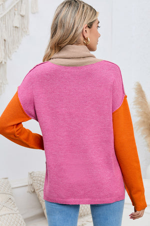 Colorblock knit turtleneck sweater in pink with tan collar and orange sleeves.