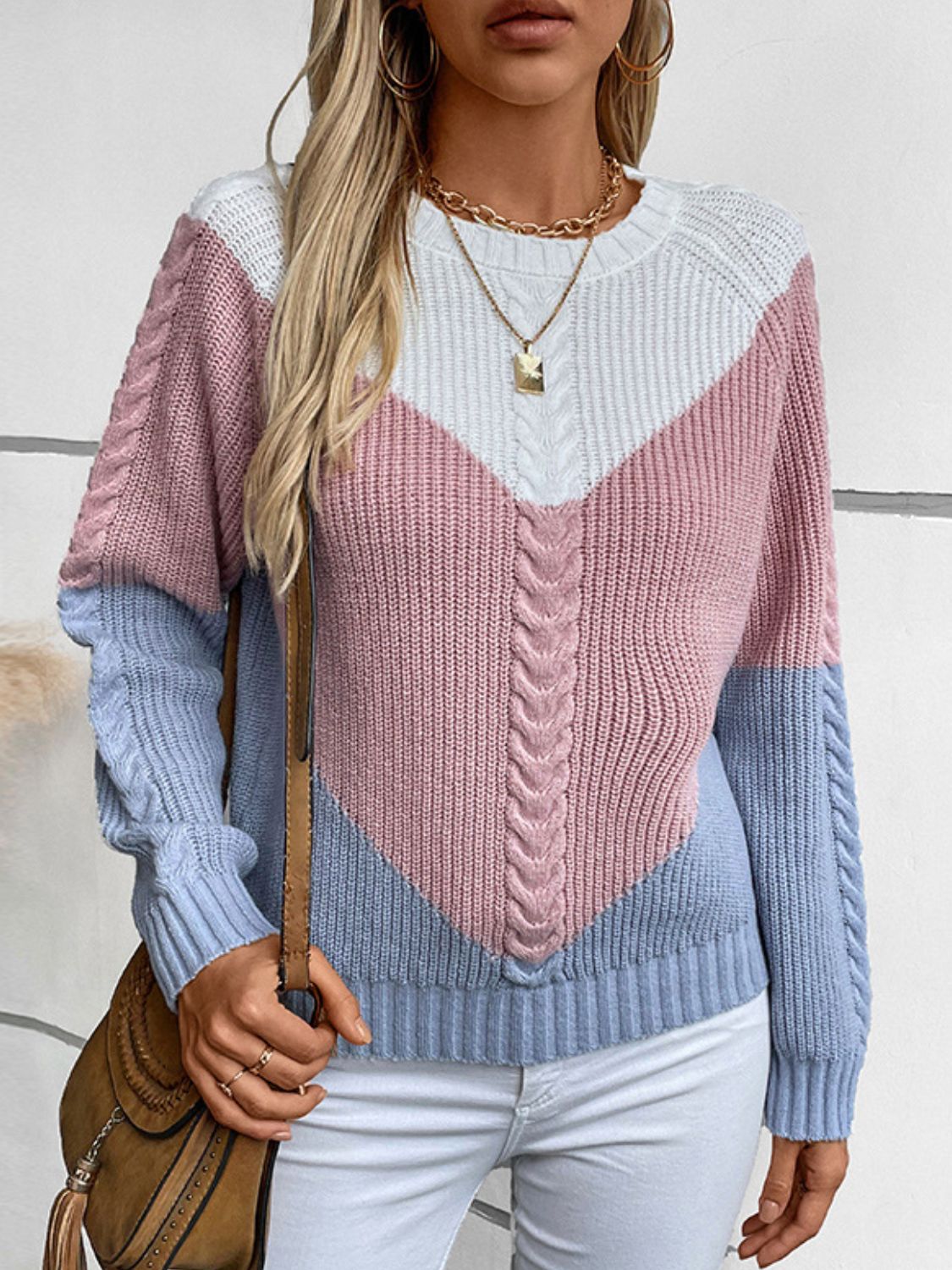 Chevron cable knit sweater in pastel blue, blush pink, and white with a V-shaped colorblock design.
