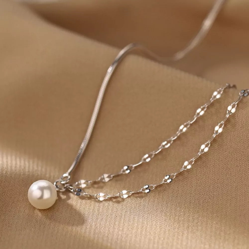 Lustrous pearl pendant layered necklace in 925 sterling silver with delicate chain detail.