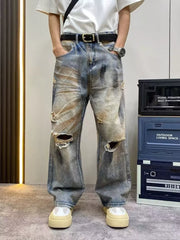 Heavily distressed vintage wide-leg jeans in blue denim with rips and faded details.