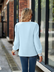 Pastel blue blouson sleeve top with embroidered trim cuffs.