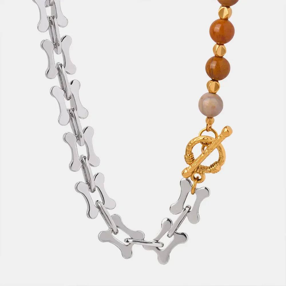 Silver asymmetrical chain necklace with bone links and beaded section with toggle clasp.