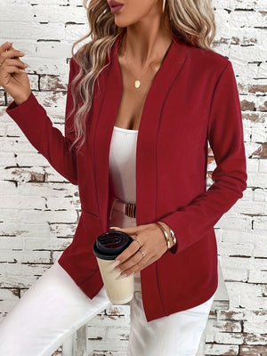 Rust open-front blazer with clean lines and long sleeves, styled with a white tank top and gold jewelry.