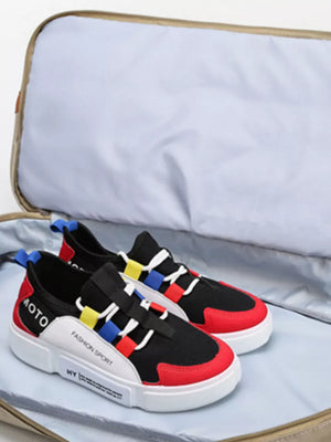Black and red fashion sport sneakers with colorful accents inside a travel bag.