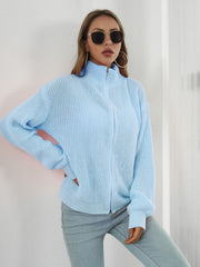 Pastel blue ribbed knit zip-up sweater with a mock neck and long sleeves.