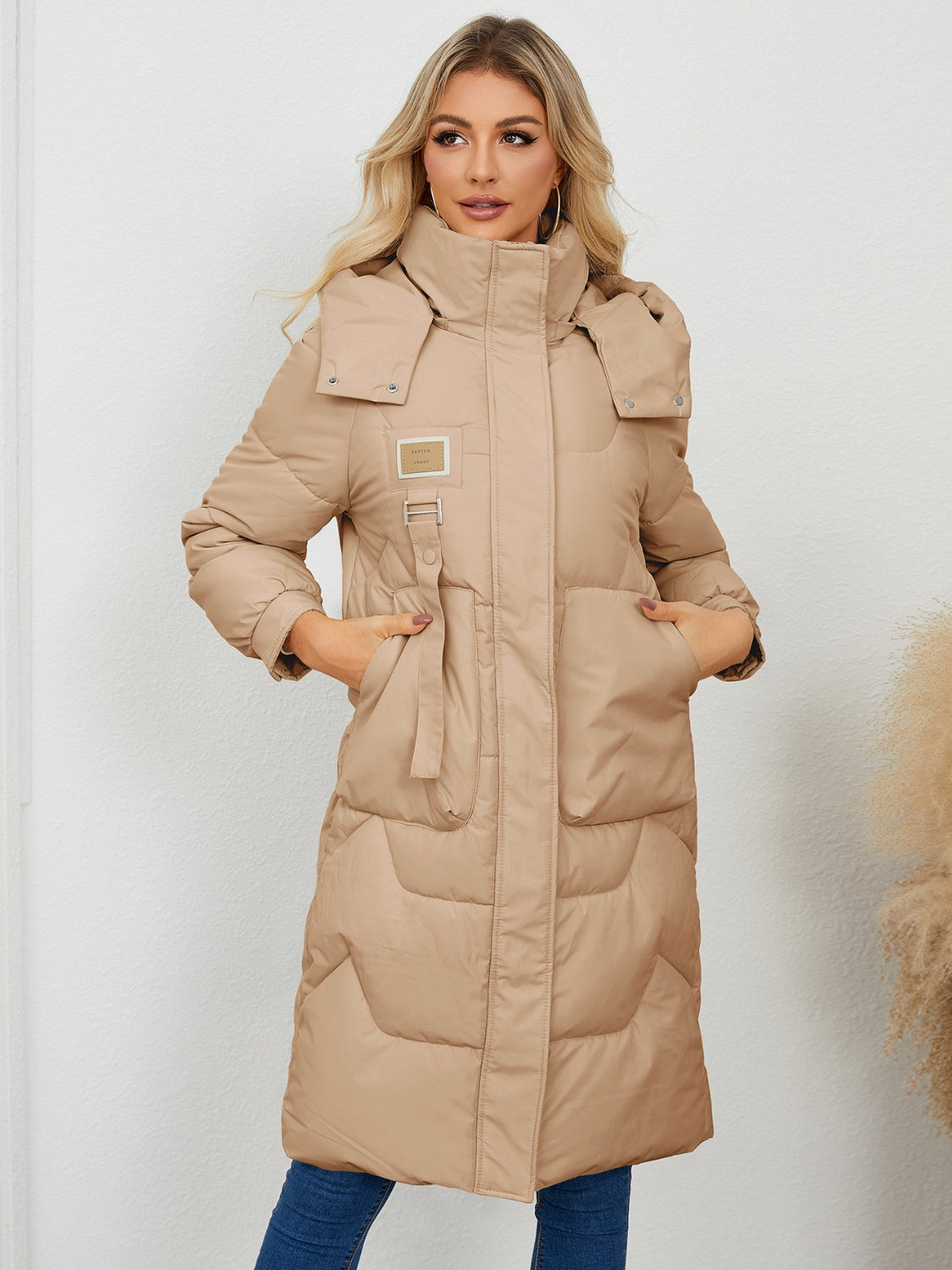Camel quilted puffer parka with buckle detail and hood, full length.