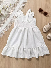 White baby dress with smocked bodice, ruffle straps, and ruffled hem.
