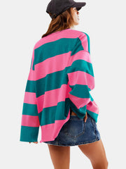 Oversized acrylic pullover with bold pink and dark green stripes, crew neck, and long sleeves.
